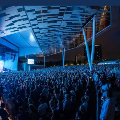 Massive amphitheater crowd in blue light