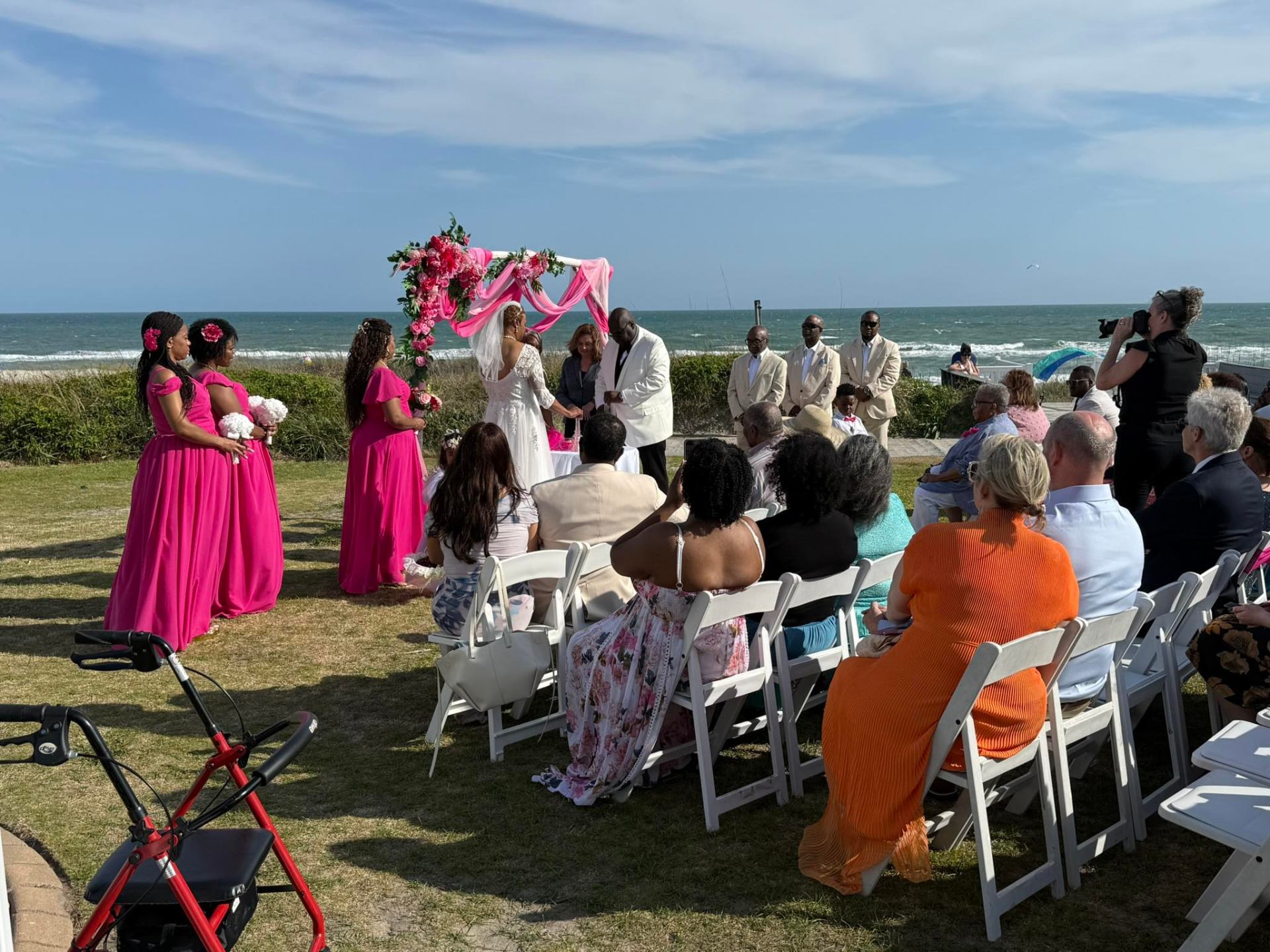 Oceanfront wedding ceremony with pink floral arch